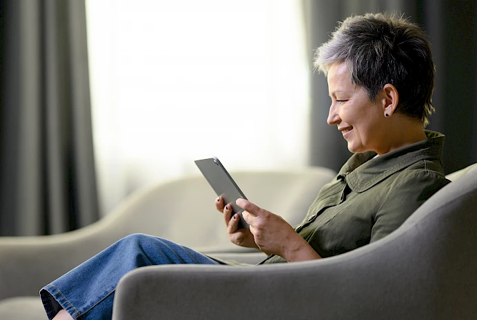 Kuvituskuva, nainen lukee verkkouutisia tablettilaitteelta